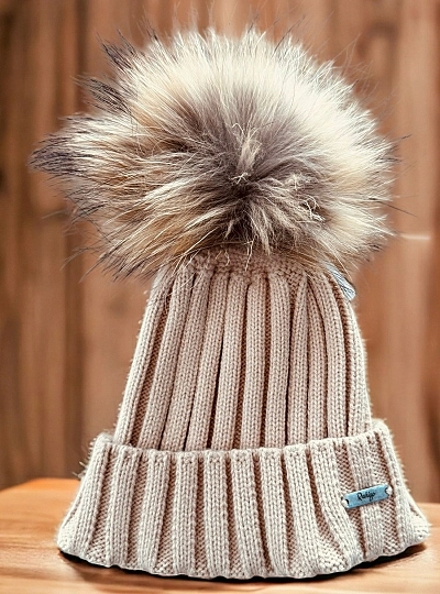 Ribbed hat in various colors. She wears a hair pompom.