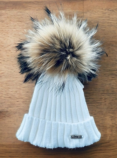 Ribbed hat in various colors. She wears a hair pompom.